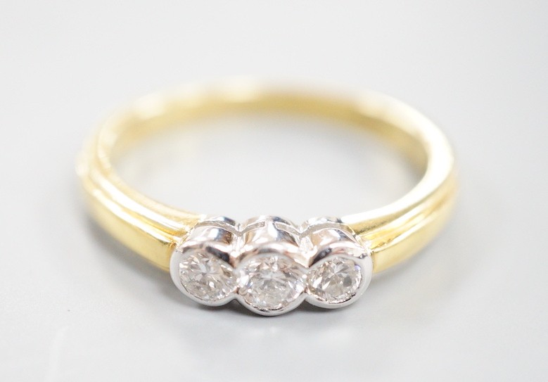 A modern 18ct gold and collet set three stone diamond ring, size P, gross weight 3.6 grams